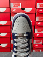 Low-top sneakers, perforated white toe cap with navy eyestays and gray lace-up.