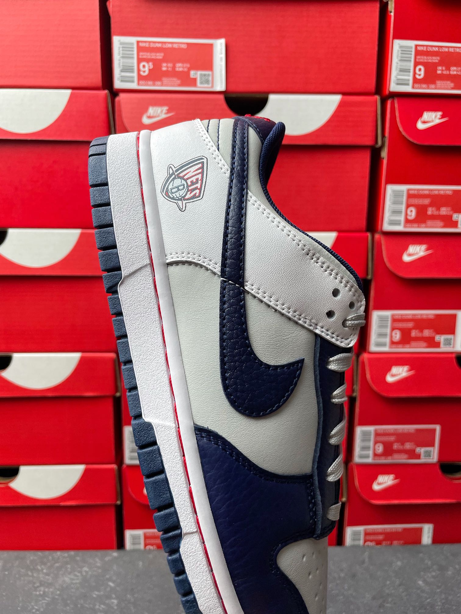 Low-top sneakers in white and navy with laced collar and team logo on heel tab.