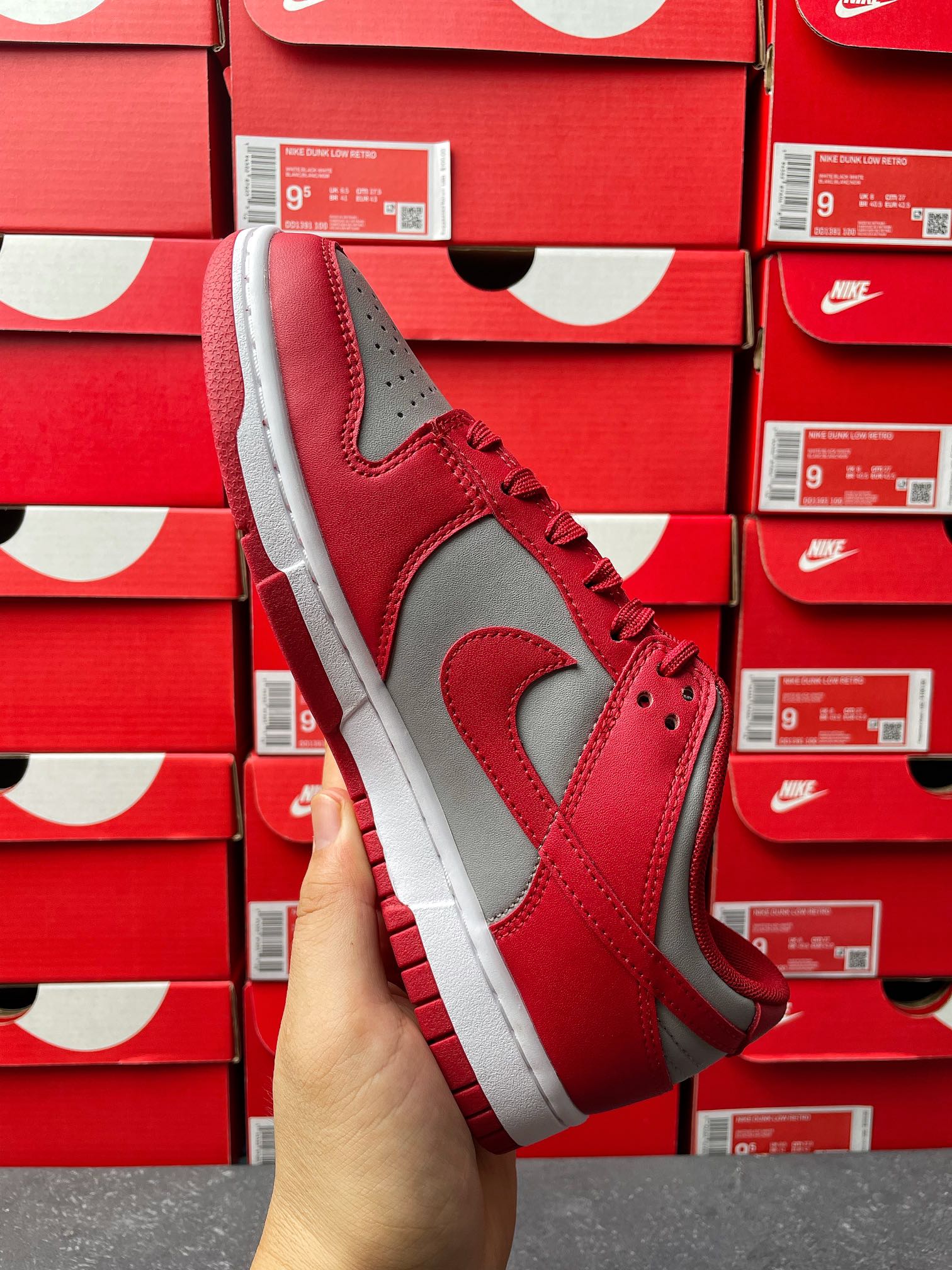 Low-top sneaker angle view with red suede-like upper, gray Swoosh, and white midsole.