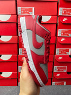 Low-top sneaker side view with red leather upper, gray Swoosh panel, and white sole.
