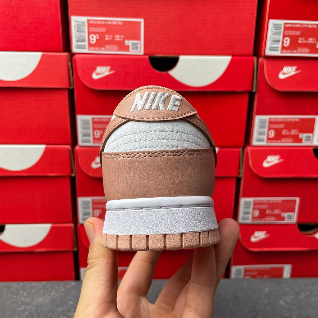 Brown and white low-top sneaker, heel view with Nike logo on back