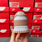 Brown and white low-top sneaker, heel view with Nike logo on back