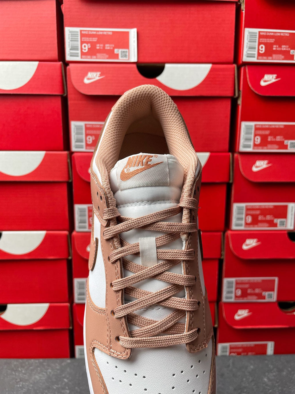 Brown and white low-top sneakers with lace-up front and padded collar