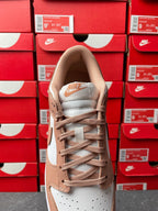 Brown and white low-top sneakers with lace-up front and padded collar