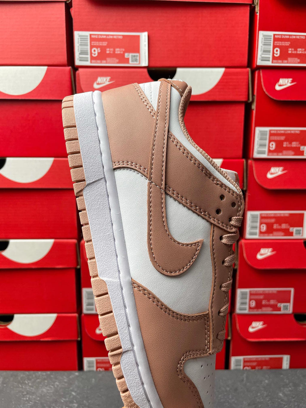 Brown and white low-top sneaker, angled side view with perforated toe