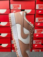 Brown and white low-top sneaker, angled side view with perforated toe
