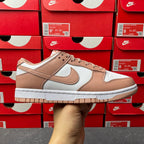 Brown and white low-top sneakers with Nike swoosh and tan lace-up panels