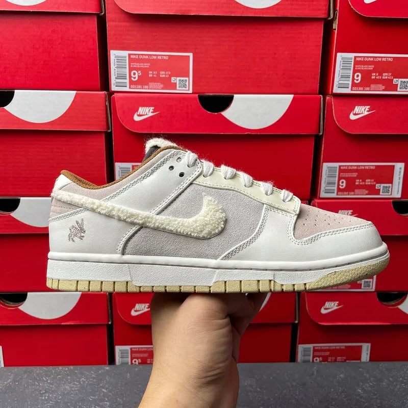 Nike Dunk Low low-top sneaker front view, light gray upper with white laces and swoosh