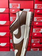 Brown and white low-top sneaker with side Swoosh and thick beige sole