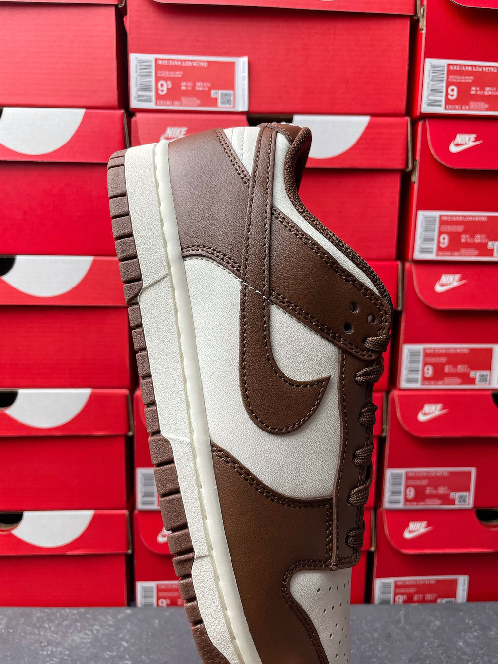 Brown suede low-top sneaker with white leather inserts, side profile