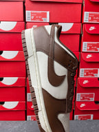 Brown suede low-top sneaker with white leather inserts, side profile