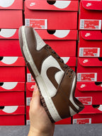 Brown suede low-top sneaker with white leather panels, angled side view