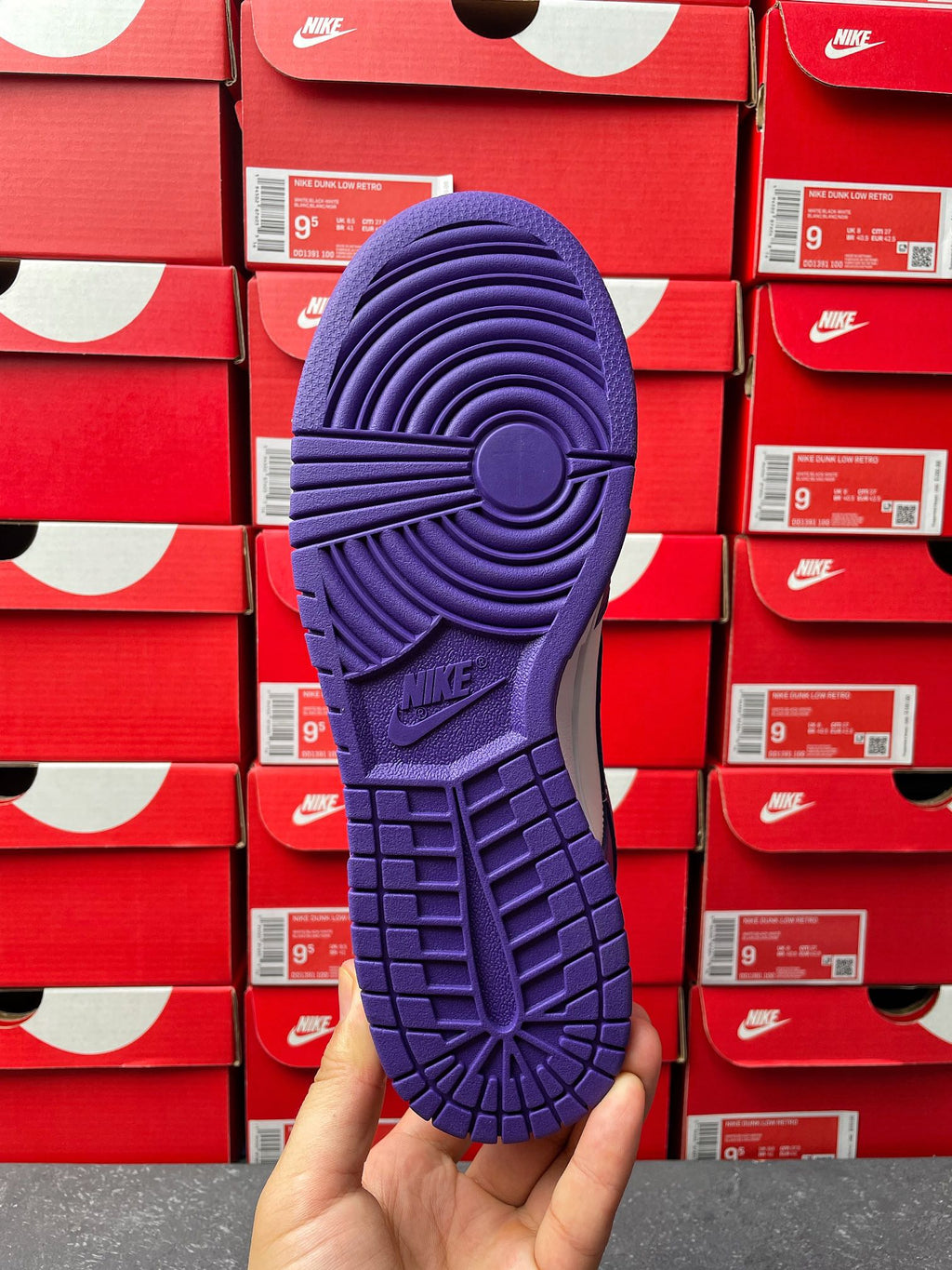 Nike Dunk Low sneaker outsole view, purple rubber tread with circular traction pattern