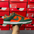 Green and orange low-top sneaker with white sole and black Nike swoosh detail.