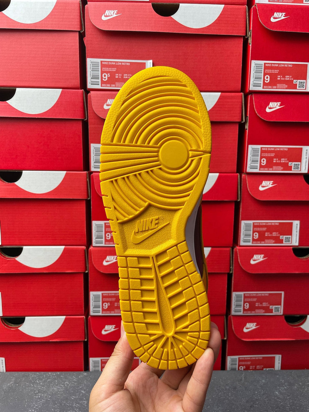 Nike Dunk Low outsole view in yellow with traction tread and NIKE logo