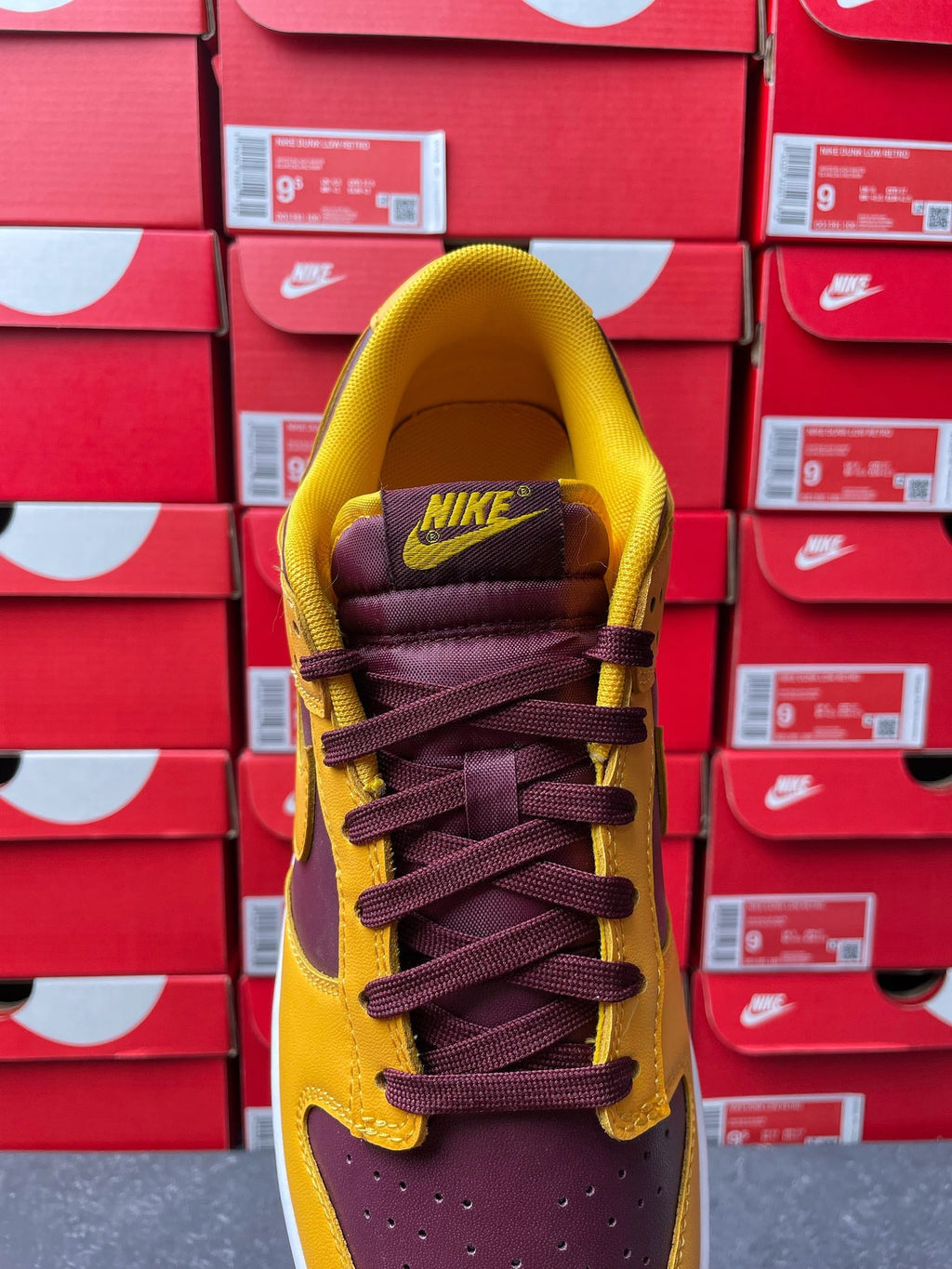 Nike Dunk Low heel view with purple collar, yellow upper, and lace-up eyelets