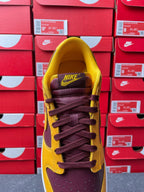 Nike Dunk Low heel view with purple collar, yellow upper, and lace-up eyelets