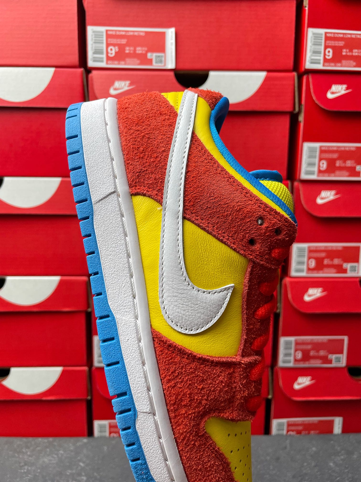 Nike Dunk Low sneaker, close-up side profile with yellow swoosh and blue outsole