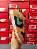 Nike Dunk Low skate shoe in orange, teal, and black with white midsole and orange tread