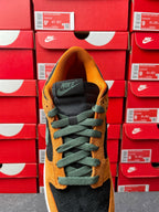Nike Dunk Low shoe with orange suede upper, green laces, and black tongue with white sole