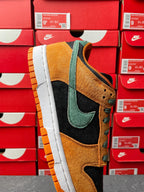Nike Dunk Low sneaker side view with orange suede, green swoosh, black overlays, white sole