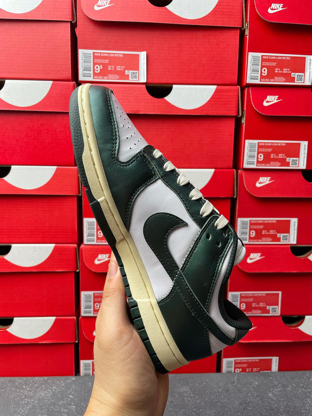 Nike Dunk Low sneaker angled view with dark green upper and white Swoosh