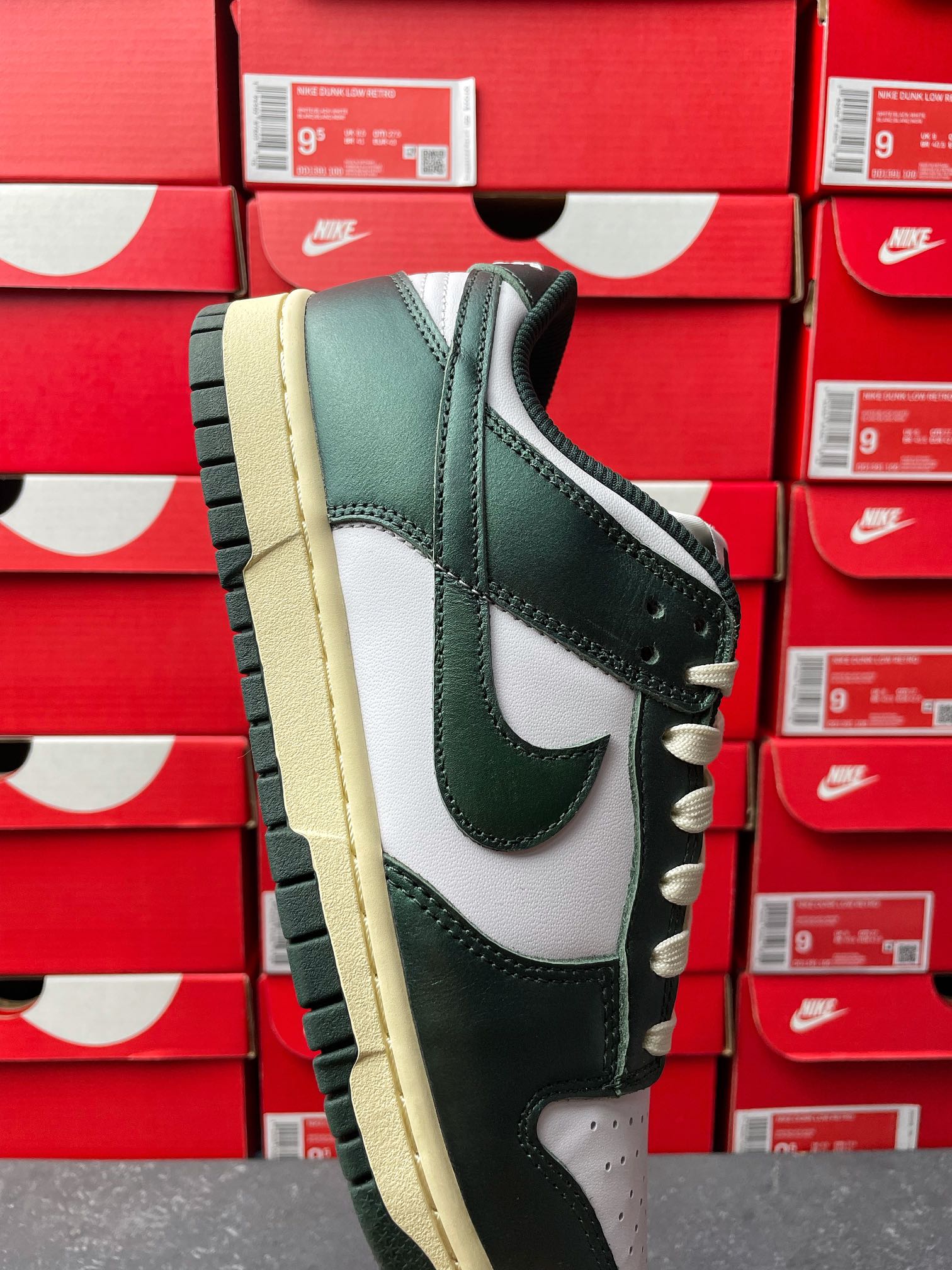 Nike Dunk Low sneaker front-side view, dark green upper with white Swoosh