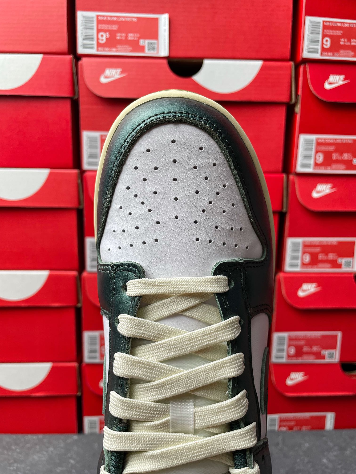 Nike Dunk Low toe view with perforated white panel and dark green leather