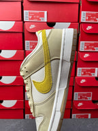 Nike Dunk Low sneaker, quarter view; cream leather with lemon-yellow swoosh