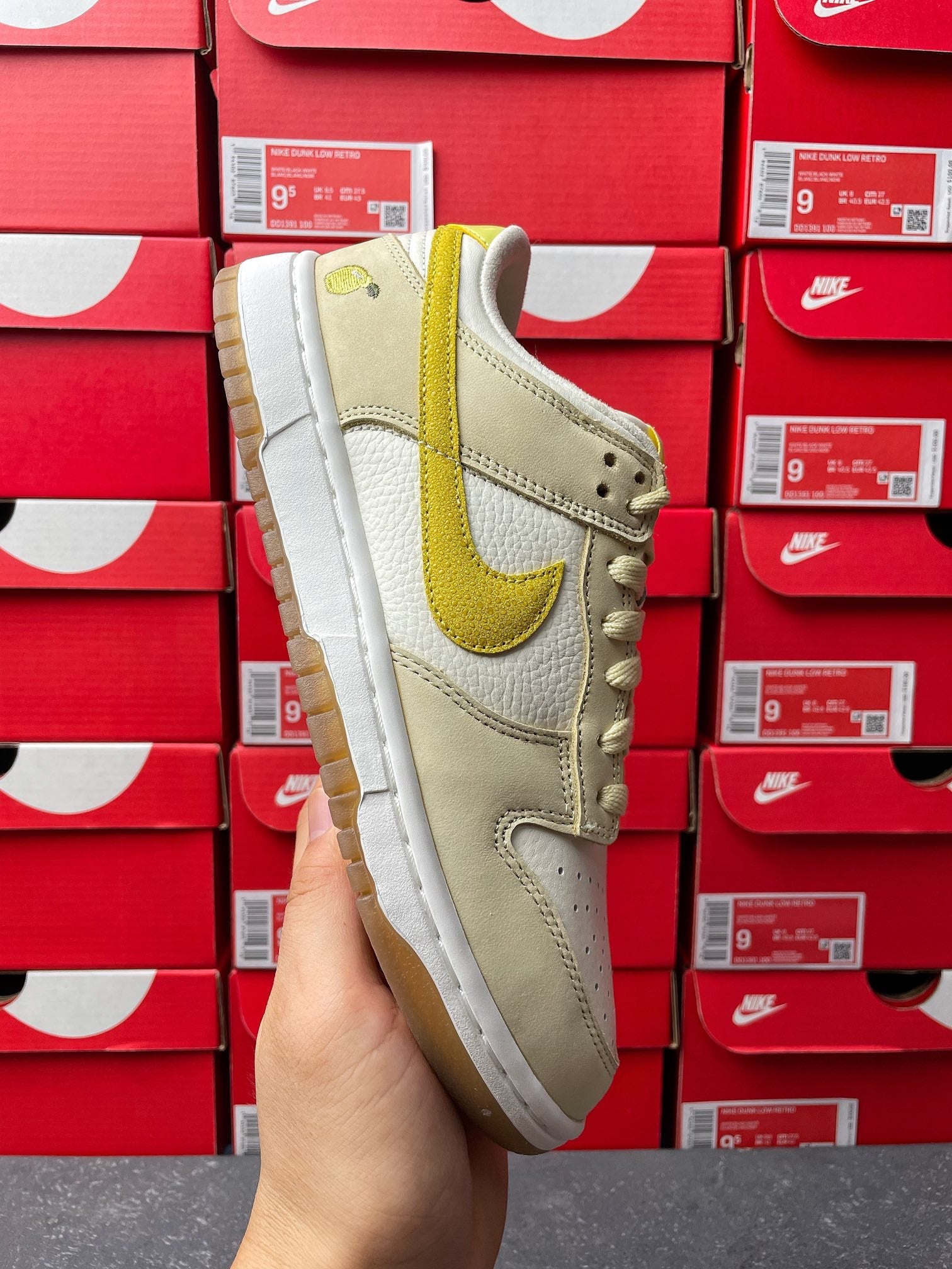 Nike Dunk Low sneaker, side view; cream upper with lemon-yellow heel swoosh