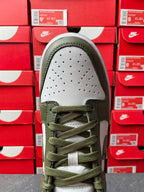 Low-top sneaker toe box in white with perforations, olive laces and olive collar.