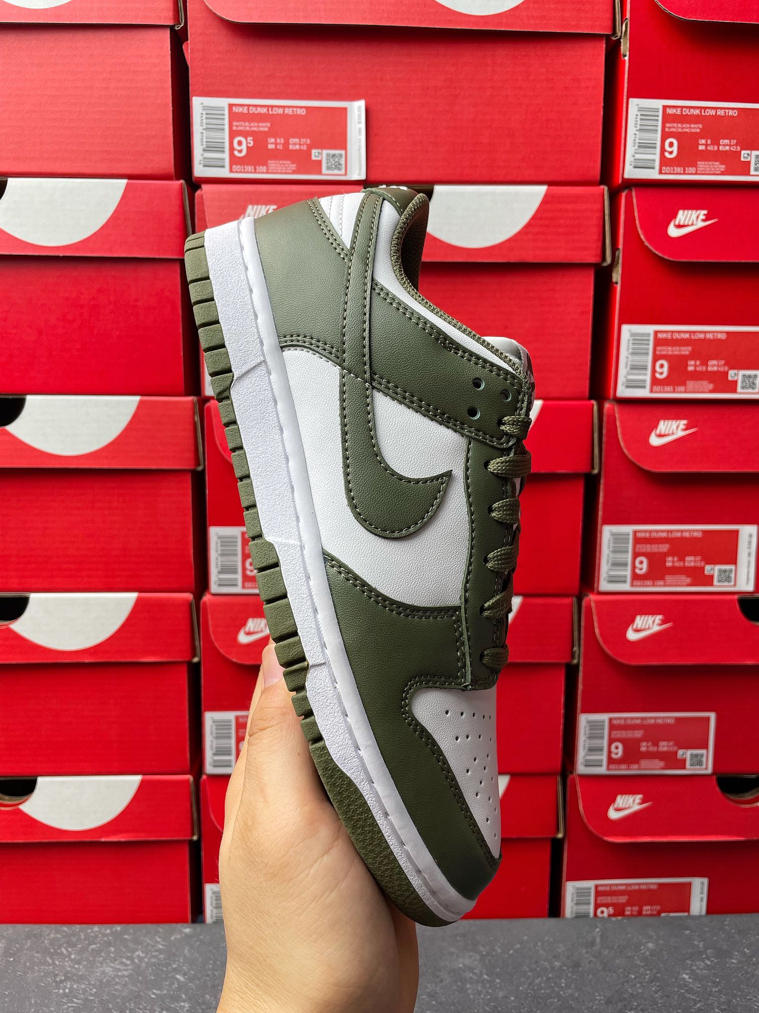 Low-top lace-up sneaker in olive green and white, side view with white swoosh.