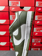Low-top sneaker side view with olive green upper, white swoosh, and thick white sole.
