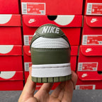 Back view of low-top sneaker with olive green leather heel and white midsole stripe.