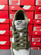 Low-top sneaker collar and tongue in olive green with white “NIKE” patch, lace-up.
