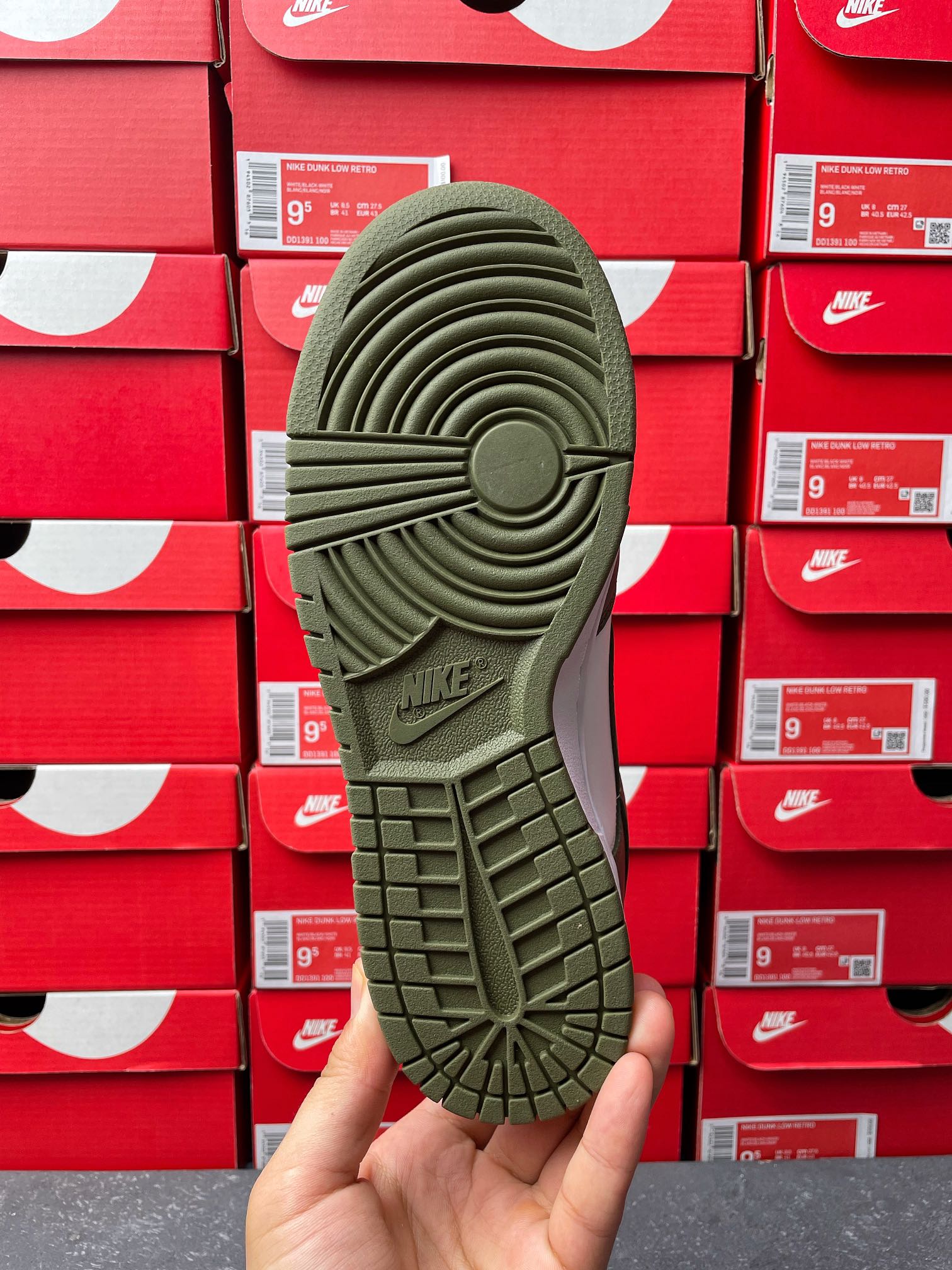 Rubber outsole for low-top sneaker in dark olive green with “NIKE” branding.