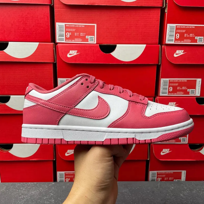 Nike Dunk Low sneakers in pink and white with perforations and thick gray sole.