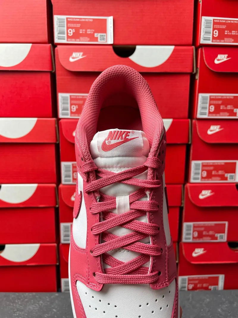 Nike Dunk Low sneakers, pink mesh lining and laces with white toe box and gray sole.