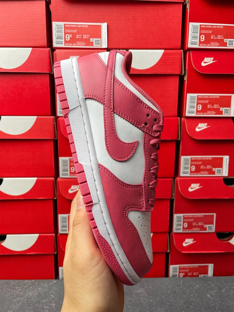 Nike Dunk Low sneakers, side profile with pink upper, white swoosh, and gray outsole.