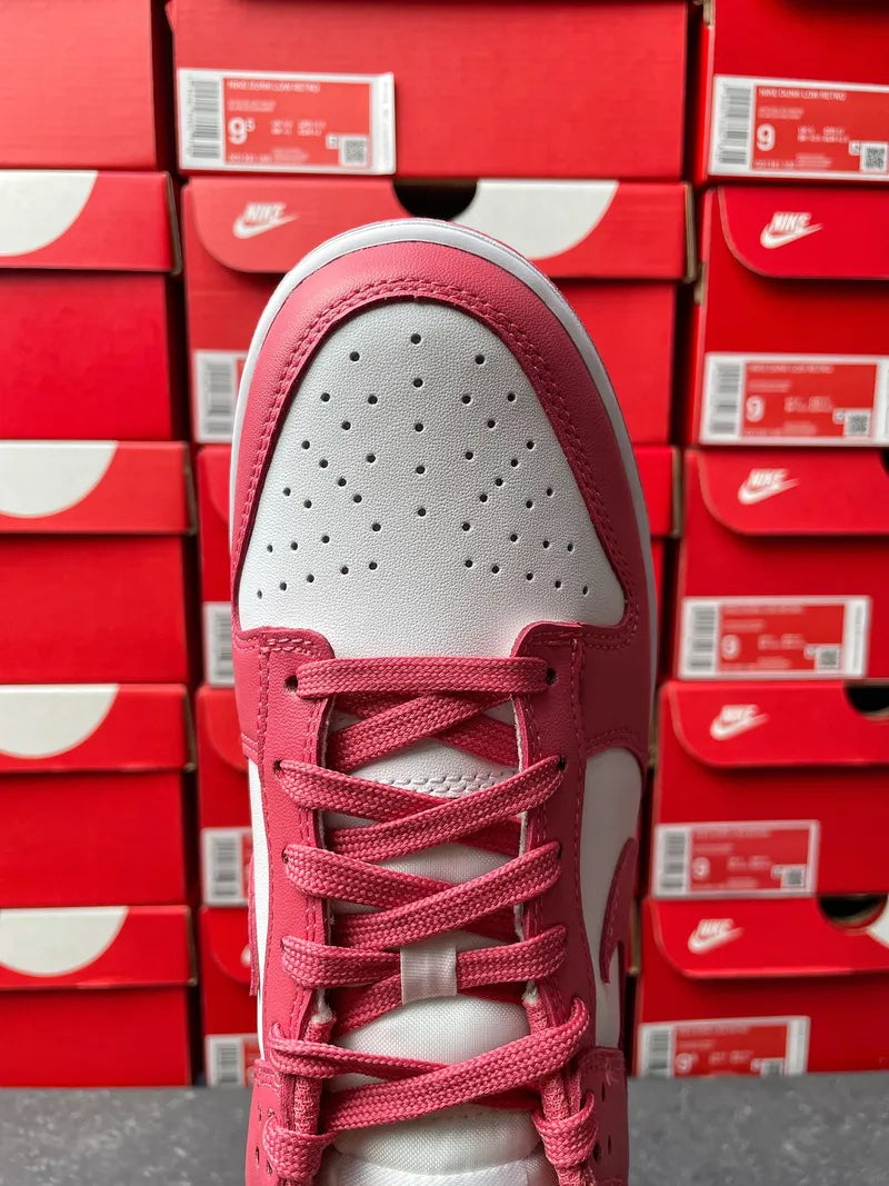 Nike Dunk Low sneakers, front view with pink laces, white toe box, and gray outsole.
