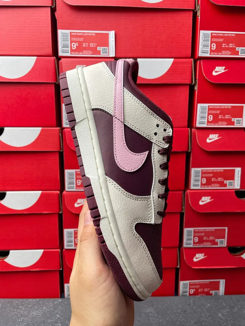 Cream leather low-top sneaker with soft pink swoosh, maroon overlays, and thick sole