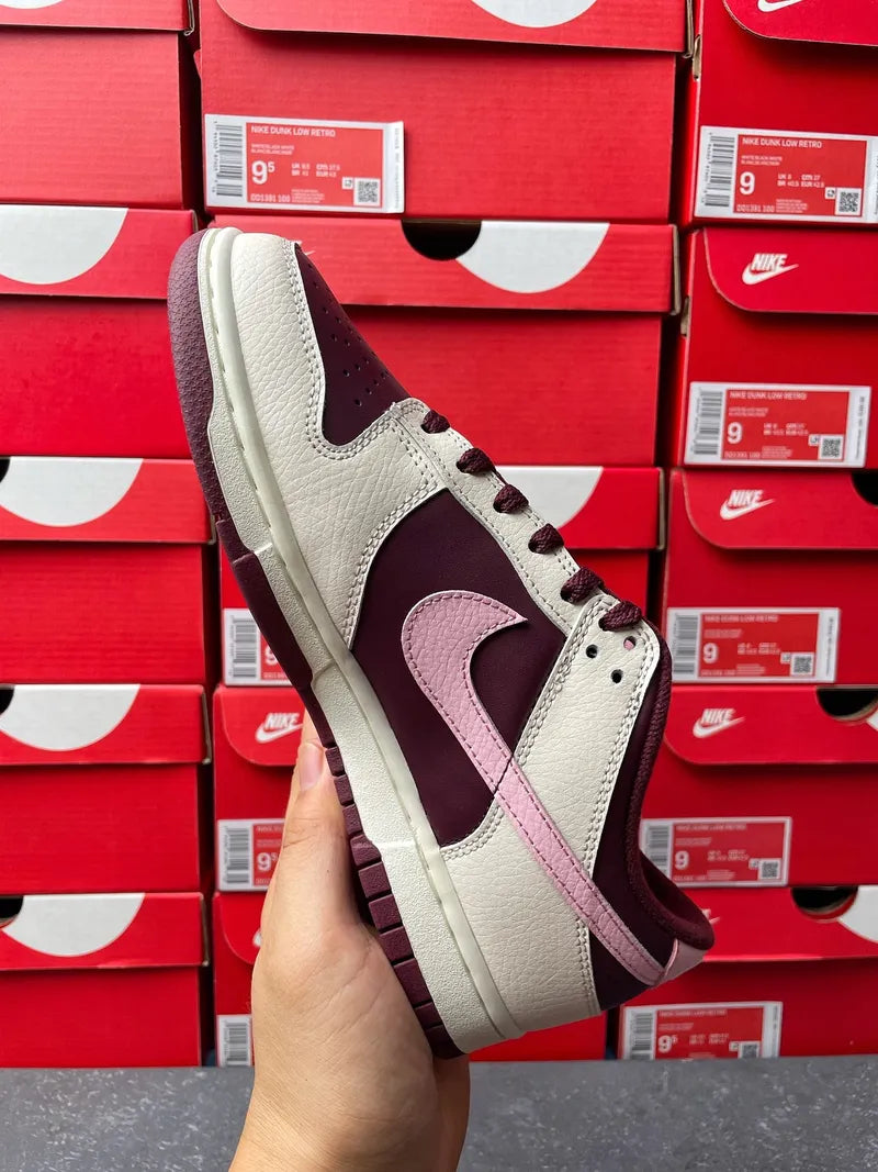 Cream leather low-top sneaker with maroon and soft pink accents and lace-up front