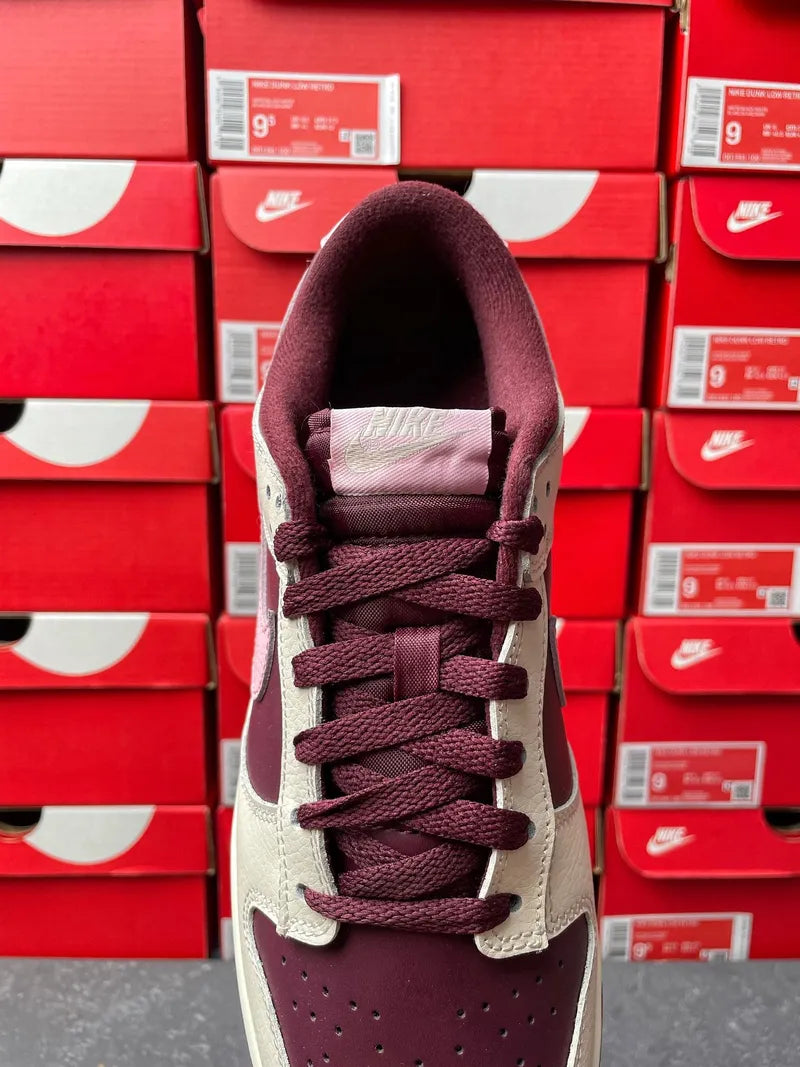 Cream leather low-top sneaker with maroon laces and perforated toe front view