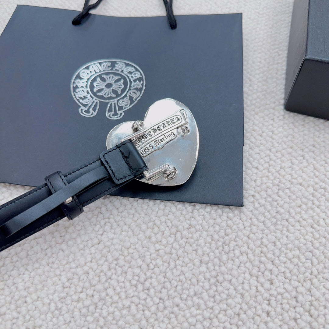 Heart-shaped silver buckle on dark blue leather belt with engraved text