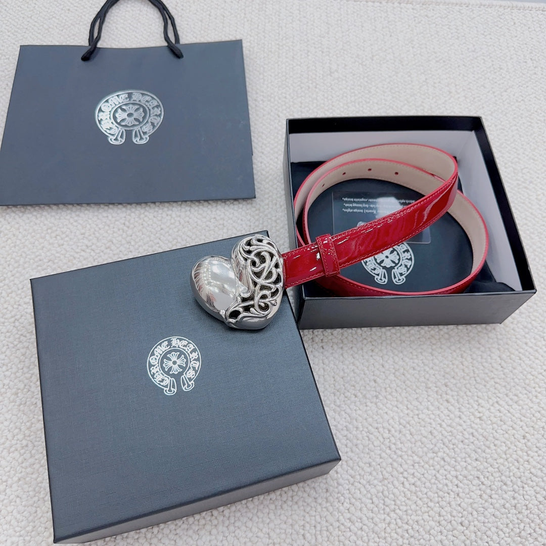 Red patent leather belt with silver heart buckle, shown in a gift box.