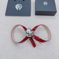 Red patent leather bow belt with silver heart buckle and decorative clasp.