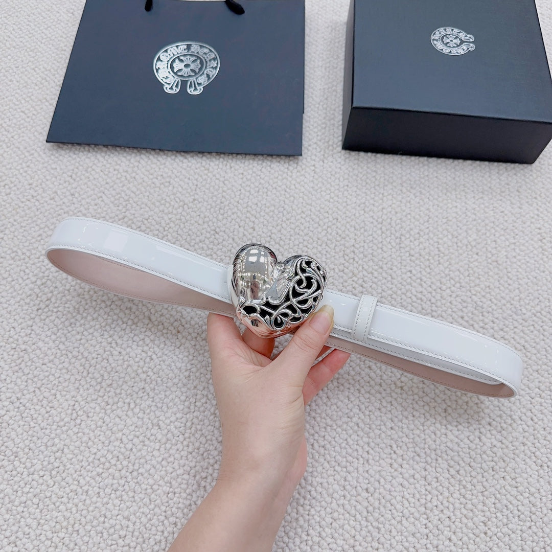 White leather belt with silver heart center buckle, held in hand