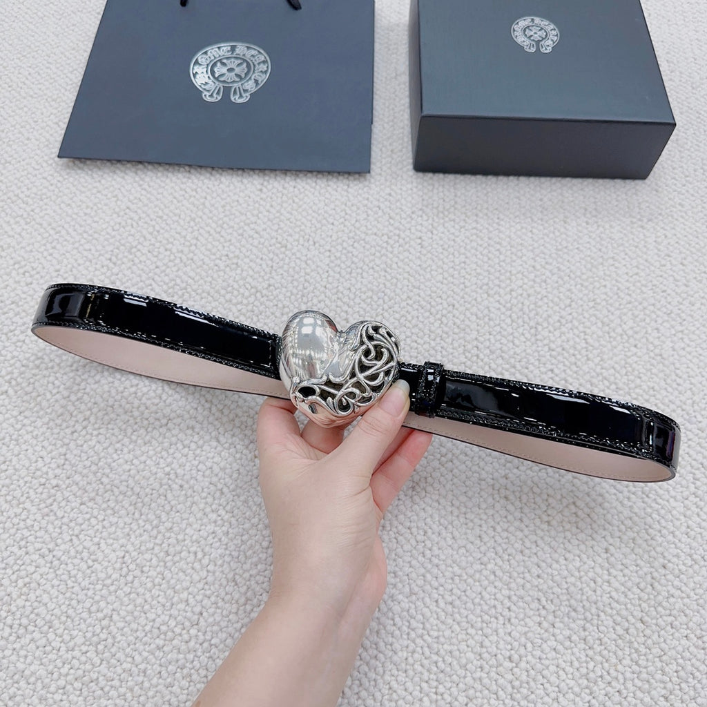 Chrome belt held flat, featuring glossy black strap and silver heart buckle detail.