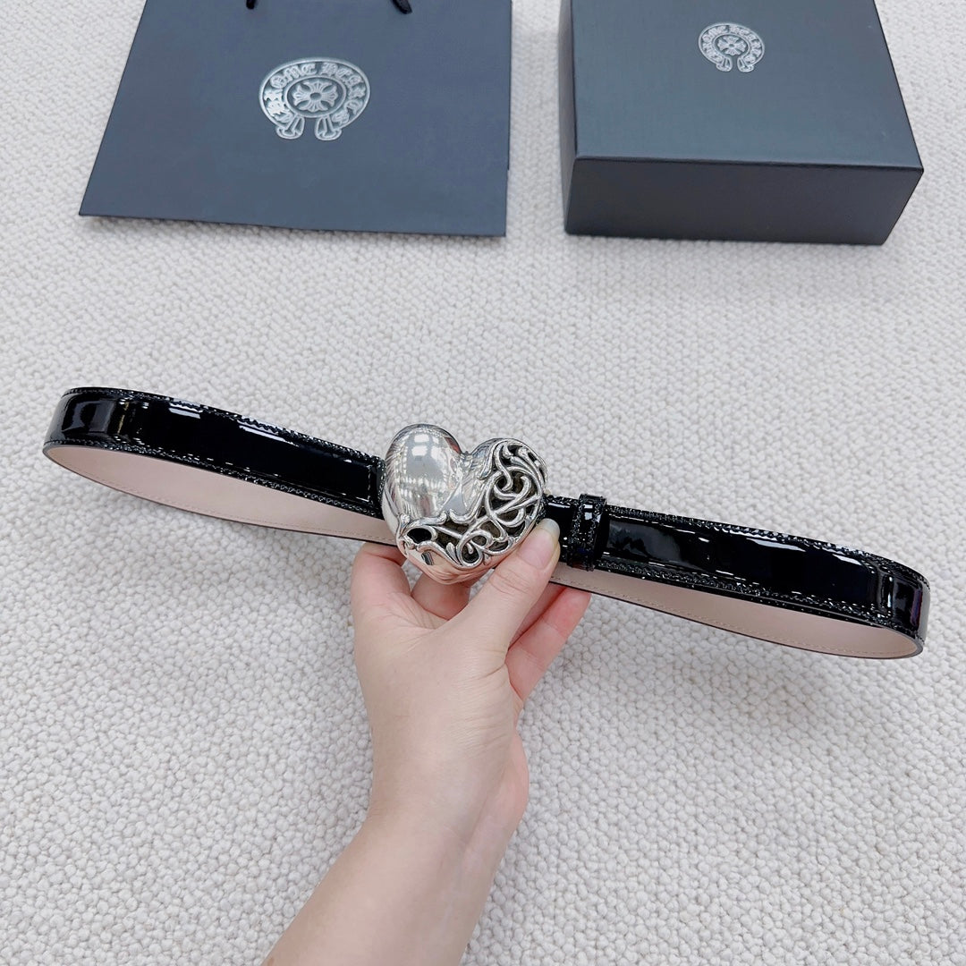 Chrome belt held flat, featuring glossy black strap and silver heart buckle detail.