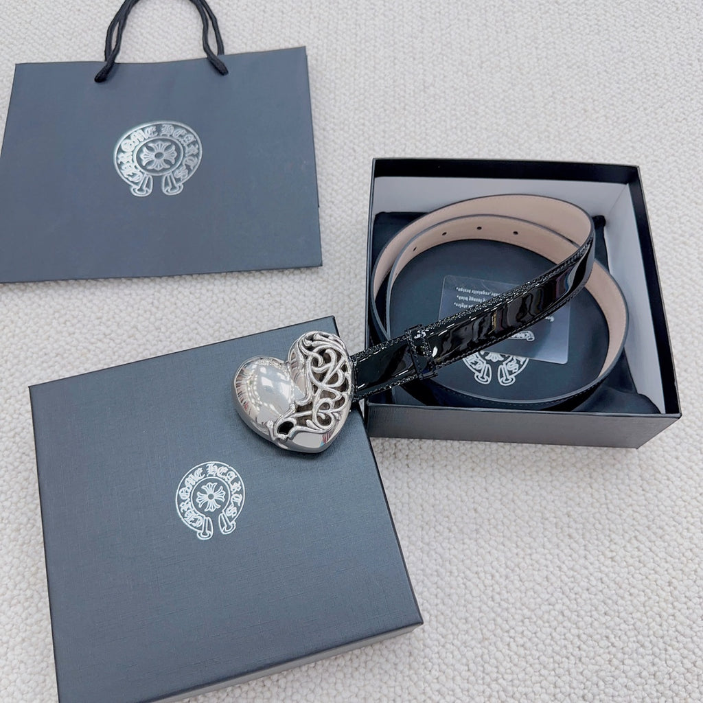 Chrome belt with glossy black strap and silver heart buckle, shown laid in a box.